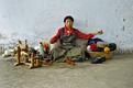 Tibeterin mit archaischem Spinnrad in Teppichmanufaktur, Shigatse
